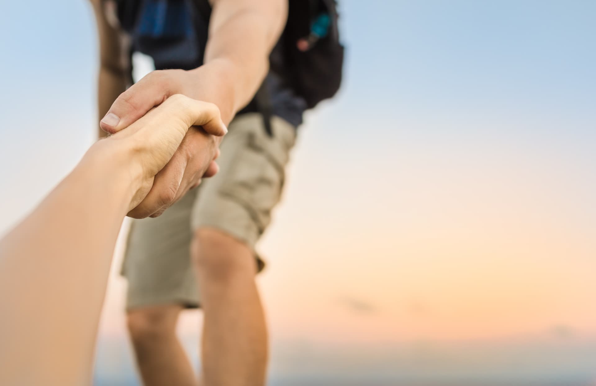 Eine Hand, die jemandem von unten nach oben hilft